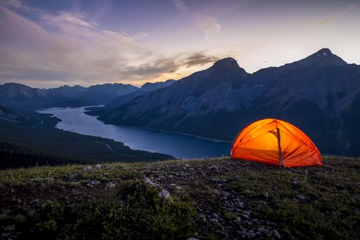 Glowing tent set up on a ridge for camping in the Rocky mountains