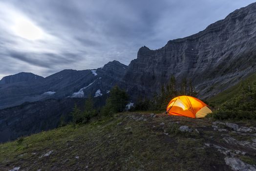 Illuminated tent camping on ridgeline of a mountain