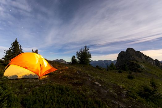 Illuminated tent camping on ridgeline of a mountain