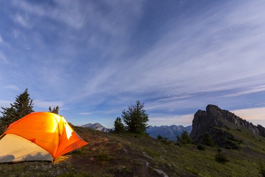 Illuminated tent camping on ridgeline of a mountain