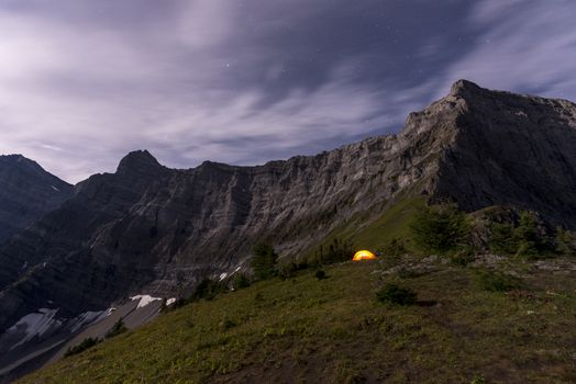 Illuminated tent camping on ridgeline of a mountain