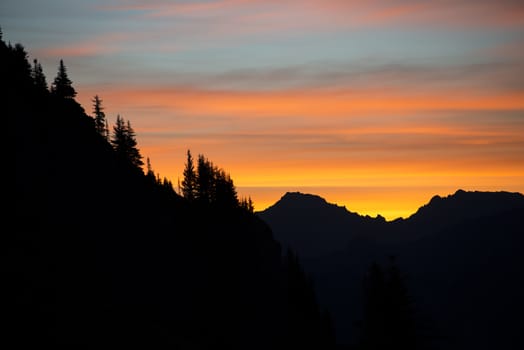 Silhouette of mountains and trees of orange sunrise