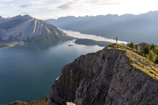 Male hiker walks along a ridge of mountain during sunrise