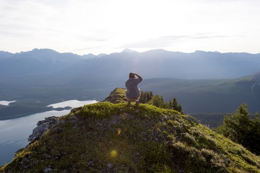 Young man taking picture at sunrise on a mountain