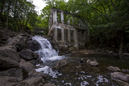 Ruins next to a waterfall in the a forest summer