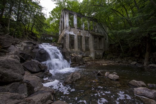 Ruins next to a waterfall in the a forest summer