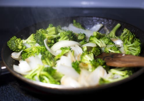 beef broccoli and onion stirfry steaming in a pan