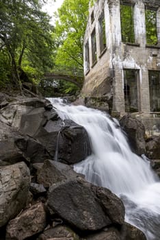 Ruins next to a waterfall in the a forest summer