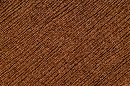 Warm brown crinkled fabric with irregular diagonal lines textile abstract background texture