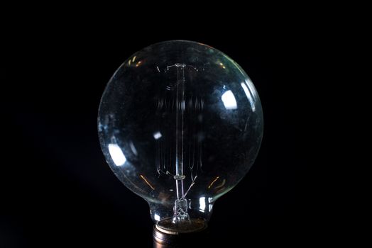 Antique unlit light bulb isolated on black background