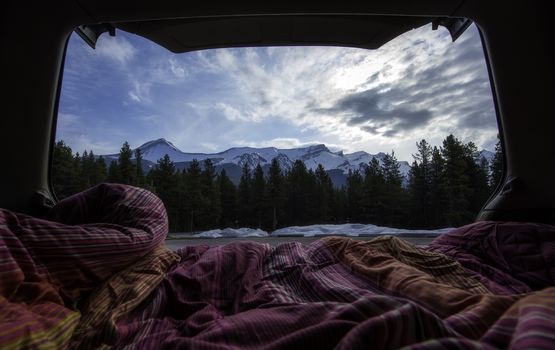 looking out the back of a car bed at mountains