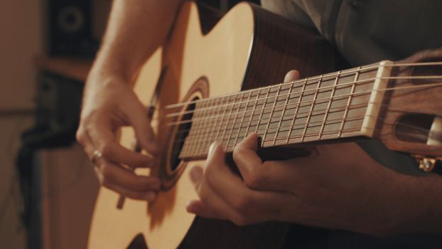 Hands of guitarist playing a guitar. Close-up