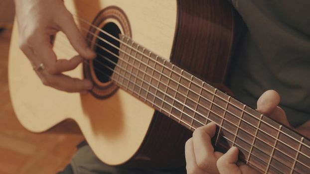 Hands of guitarist playing a guitar. Close-up