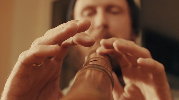 Portrait and hands of musician plays the flute. Close up