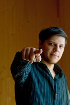 Young man pointing a finger to camera