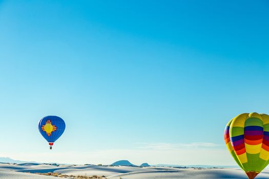 Colorful hot air balloons fly over the glistening gypsum dunes at White Sands National Monument during the 2016 Balloon Invitational.