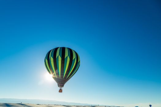 Colorful hot air balloons fly over the glistening gypsum dunes at White Sands National Monument during the 2016 Balloon Invitational.