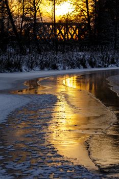 Colorful evening with golden reflection on the winter river