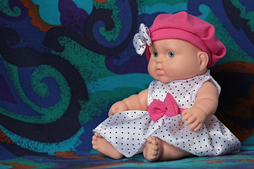 little doll baby in a beret with a bow macro shot