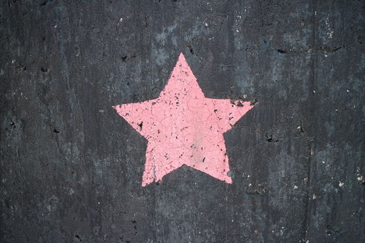 five-pointed star of pink color on a dark background