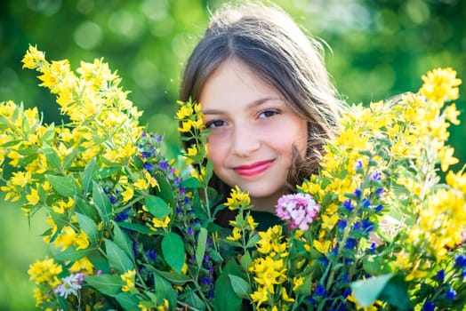 portrait of a girl with flowers in summer sunny day