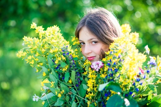 portrait of a girl with flowers in summer sunny day