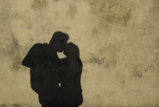 shadow on a wall of a couple kissing