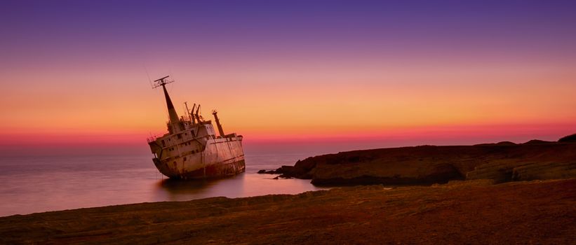 Seascape: famouse boat, shipwrecked near the rocky shore at the sunset. Mediterranean, near Paphos. Cyprus.