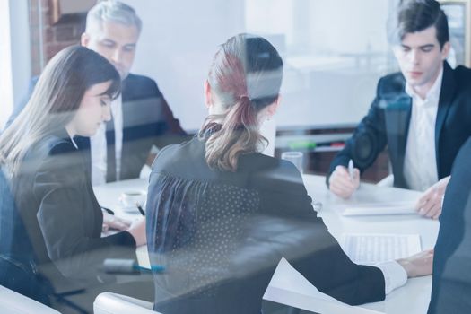 Business colleagues meeting in conference room, shot through glass