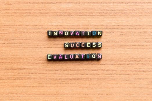 innovation success evaluation words in wooden background