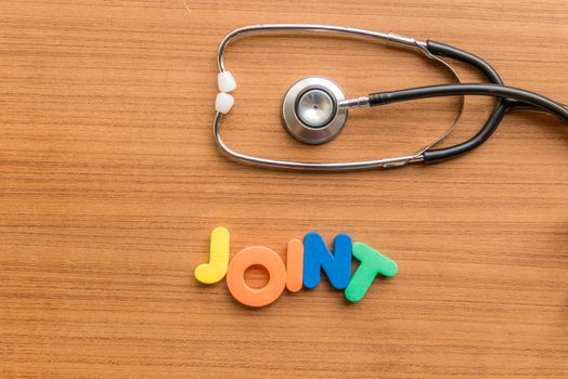 joint colorful word with Stethoscope on wooden background