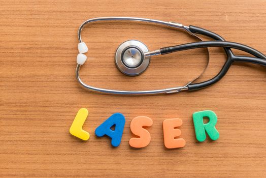 laser colorful word with Stethoscope on wooden background