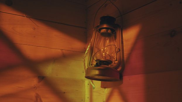 Ancient lamp on a wooden wall. Reflection of stained-glass window. Close up