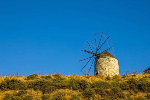 One of the last windmills in the island of Naxos over the blue sky