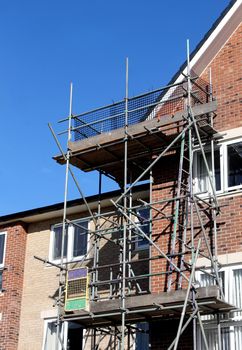 Scaffolding on exterior of modern building with blue sky background.