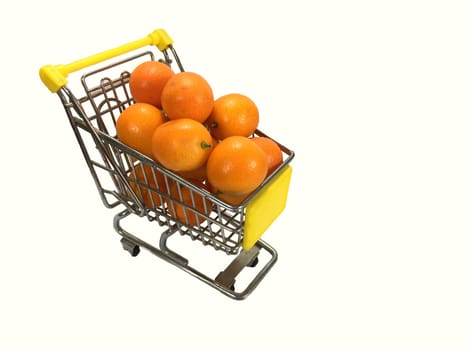 Closeup of shopping cart full of oranges on white background.