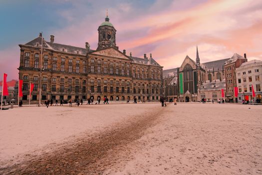 Snowy Damsquare in Amsterdam the Netherlands in winter at sunset