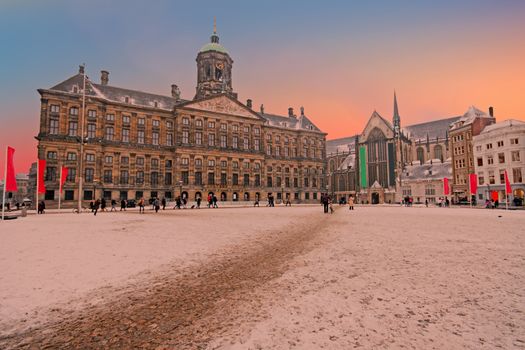 Snowy Damsquare in Amsterdam the Netherlands in winter at sunset