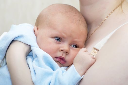 Newborn baby on mother's arms close up shot