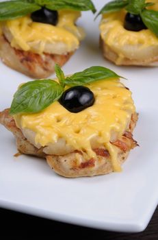 pieces of chicken fillet    a slice of pineapple with cheese