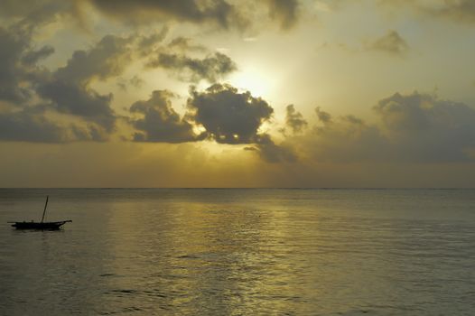 Sunset on the beach of Bamburi with a dhow and the Indian ocean