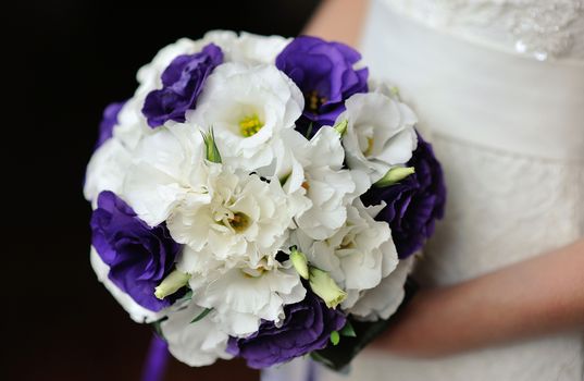 Bride holding beautiful wedding bouquet on walking time.