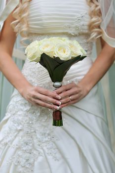 Bride holding beautiful wedding bouquet on walking time.