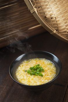 Asian style porridge bowl on rustic wooden table background.