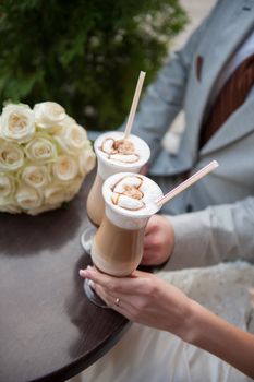 bride and groom drink latte with painted hearts.