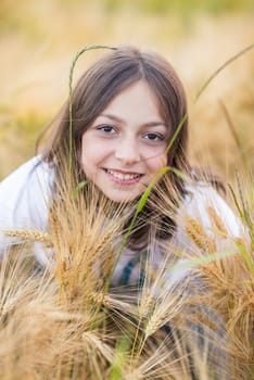 Portrait of a Girl in wheat field in summer sunny day