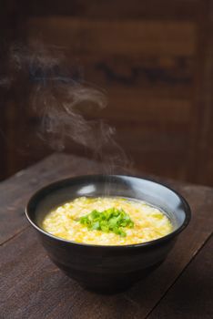 Asian porridge bowl on rustic wooden table background.