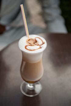 cup of latte on a table and two hearts drawn.