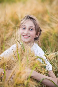 Portrait of a Girl in wheat field in summer sunny day