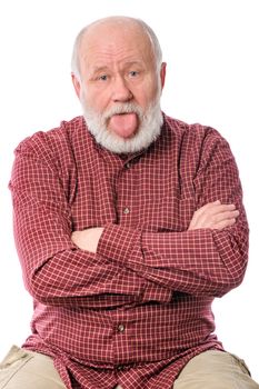 Cheerful and calm handsome bald and bearded senior man sitting with arms crossed and tongue sticking out, isolated on white background